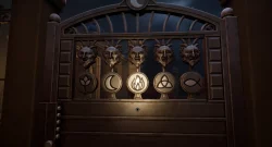 Ornate metal gate with five circular medallions bearing different symbols (leaf, crescent, flame, knot, oval) under carved masks, at night.