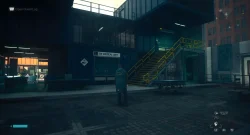 Nighttime hospital exterior with ER Medical Unit sign, yellow stairs, and a person in a long coat facing away from the camera.